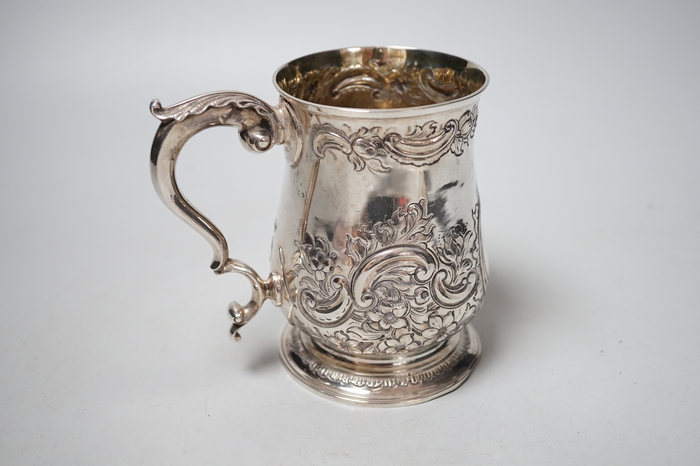 A George III silver mug, with late embossed decoration, John Scofield, 1772, 11.7cm, 9.9oz.